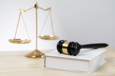 Adaleti ve hukuki otoriteyi temsil eden, altın dengeli ölçeği temsil eden ve avukatlık arka planında hukuk kitabı olan tokmağı, eşitlik ve adil yargı kavramını yansıtan. denge