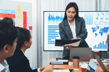 Genç Asyalı iş kadını modern toplantıda TV ekranında veri analizi paneli sunuyor. Bir grup iş adamıyla konferans odasında iş sunumu. Uyum