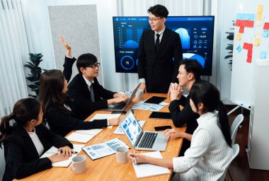 Confidence and asian businessman give presentation on financial analyzed by business intelligence in dashboard report to other people in board room meeting to promote harmony in workplace.