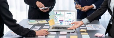 Analizci ekibi yaratıcı ve analitik beyin fırtınası fikri için bilgisayar ekranında BI veri paneli olan yapışkan bir not kullanıyor. Pazarlama stratejisi için finansal veri görselleştirme teknolojisini analiz et. Dahi.