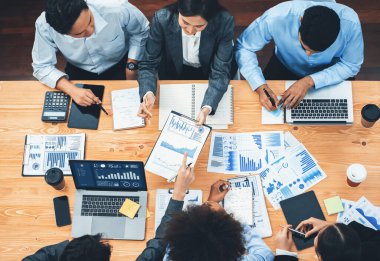 Çok ırklı analist ekibi toplantıdaki finansal verileri analiz etmek için BI Fintech yazılımı kullanıyor. Üst görünüm finans paneli veri ekranında pazarlama göstergesi için analiz edilmiş grafikle birlikte. Uyum