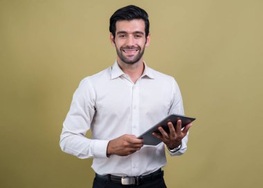 Resmi takım elbiseli kendine güvenen işadamı elinde tabletle sürpriz bir şekilde terfi ya da reklam arıyor. Yüz ifadeleri ve jestler, izole bir arkaplanda heyecan ve şaşkınlığa işaret ediyor. Coşkulu