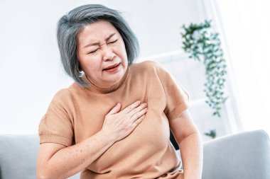 An agonizing elderly woman is experiencing chest pain. Medical attention, senior care service.