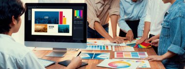 Grafik tasarımcısı, modern dijital stüdyo işyerinde profesyonel grafik ekibiyle benzersiz bir tasarım yaparken bilgisayar dizüstü bilgisayar ve grafik çizim kalemi üzerinde çalışır. Panorama çekimi. İnceleyin