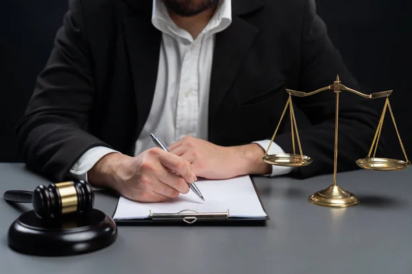 제도의 성실성 공정성을 변호사나 판사의 책상에서 서명하는 배경에 저울의 상징을 — 스톡 사진