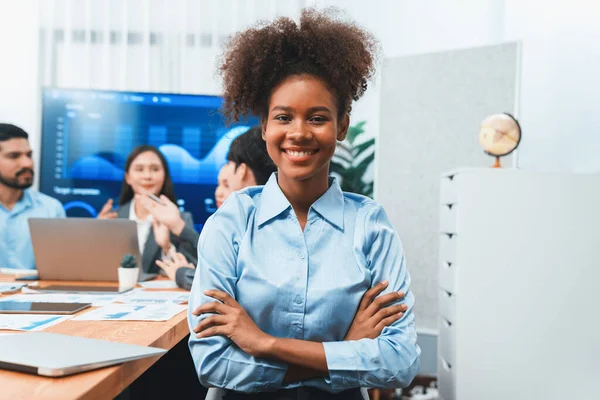 stock image Portrait of happy young african businesswoman with group of office worker on meeting with screen display business dashboard in background. Confident office lady at team meeting. Concord