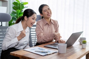 Modern ofis çalışma alanında iş birliği yapan iki genç ofis çalışanı, modern ofis çalışanı olarak profesyonelliklerini sergileyerek, dizüstü bilgisayarda tartışıyorlar ve birlikte çalışıyorlar. Coşkulu.