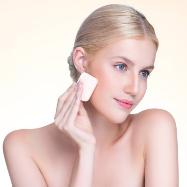 Closeup personable beautiful natural soft makeup woman using powder puff for facial makeup concept. Cushion foundation applying on young girl face in isolated background.
