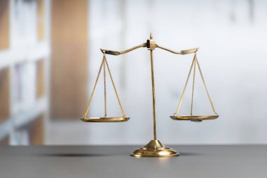 Mahkeme kütüphanesinin arka planında adalet ve adalet sembolü olarak parlak altın dengeli bir terazi. Avukat ve avukatın adil ve eşitlik kararı için terazi uygulayın. denge
