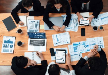 Top-view business team of financial data analysis meeting with business intelligence, report paper and dashboard on laptop for marketing strategy. Business people working together in office of harmony