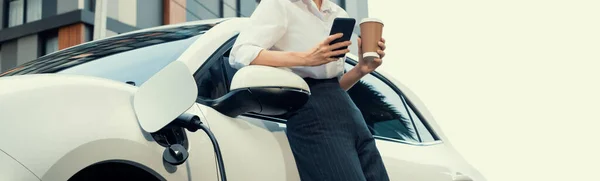 Focus Businessman Using Phone Leaning Electric Vehicle Holding Coffee Blurred — Foto de Stock