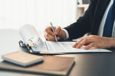 İş adamı sözleşme kağıtlarını ya da iş hukukunu güven ve profesyonellikle imzalar. Resmi iş anlaşması için şirket toplantısında el ele tutuşmak. Eşitlik