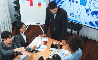 Modern toplantı odasındaki TV ekranında veri analizi paneliyle üst görünüm iş sunumu. İş adamlarının iş pazarlama stratejisini planlamak için beyin fırtınası yapması ya da birlikte çalışması. Uyum
