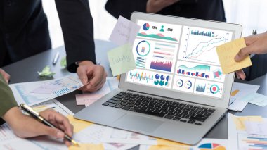 Analizci ekibi yaratıcı ve analitik beyin fırtınası fikri için bilgisayar ekranında BI veri paneli olan yapışkan bir not kullanıyor. Pazarlama stratejisi için finansal veri görselleştirme teknolojisini analiz et. Dahi.