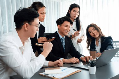 Harmony in office concept as business people analyzing dashboard paper together in workplace. Young colleagues give ideas at manager desk for discussion or strategy planning about project.