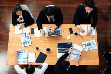 Top-view business team of financial data analysis meeting with business intelligence, report paper and dashboard on laptop for marketing strategy. Business people working together in office of harmony