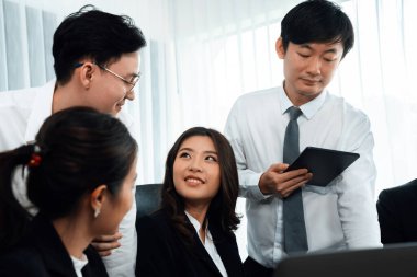 Harmony in office concept as business people analyzing dashboard paper together in workplace. Young colleagues give ideas at manager desk for discussion or strategy planning about project.