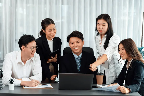 Harmony in office concept as business people analyzing dashboard paper together in workplace. Young colleagues give ideas at manager desk for discussion or strategy planning about project.