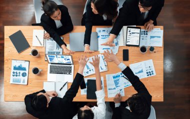 Top-view business team of financial data analysis meeting with business intelligence, report paper and dashboard on laptop for marketing strategy. Business people working together in office of harmony