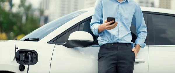 Suit Clad Progressive Businessman Look Cars Battery Status His Phone — Foto de Stock