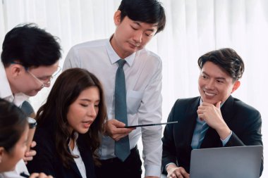 Harmony in office concept as business people analyzing dashboard paper together in workplace. Young colleagues give ideas at manager desk for discussion or strategy planning about project.
