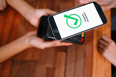 QR kodu parasız ödeme taraması için ekranda gösterilir. Kapalı eller, mobil uygulamadan elektronik işlem yoluyla para aktarmak için akıllı telefonu tutuyor. Hızlı ödeme için barkod teknolojisi. Coşkulu.