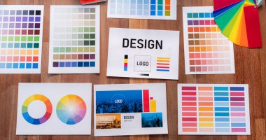 Grafik tasarım konsepti için çalışma masasının üzerine düzgünce düzenlenmiş çeşitli renk paleti fikir kağıtlarının panorama çekimi. Benzersiz dijital sanat tasarımı için renk örnekleri ve seçim. İnceleyin