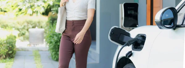 Progressive Asian Woman Electric Car Home Charging Station Concept Use — 图库照片