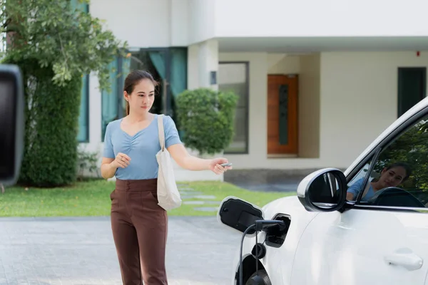 Asyalı Bir Kadın Garajında Uzaktan Kumandalı Araba Anahtarıyla Elektrikli Arabayı — Stok fotoğraf