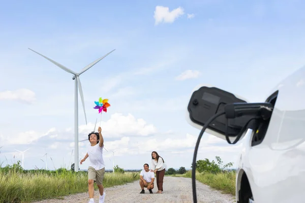 Концепція Прогресивної Щасливої Сім Тримає Вітряну Іграшку Відпочиває Вітроелектростанції Електромобілем — стокове фото