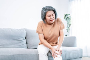 An agonizing elderly woman is experiencing chest pain. Medical attention, medical service for seniors.