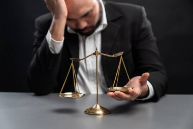 Resmi siyah davadaki avukat ya da yargıç, dengesizliği adalet sistemindeki yolsuzlukla mücadele için adaletsizliğe karşı bir kavram olarak düzeltmeye çalışırken hayal kırıklığı ifadesiyle dengesizlik gösteriyor. denge