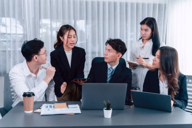 Harmony in office concept as business people analyzing dashboard paper together in workplace. Young colleagues give ideas at manager desk for discussion or strategy planning about project.