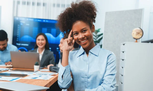背景には 画面表示ビジネスダッシュボードと会議中のオフィスワーカーのグループと幸せな若いアフリカのビジネスマンの肖像画 チームミーティングで事務所の女性を自信を持って 契約書 — ストック写真