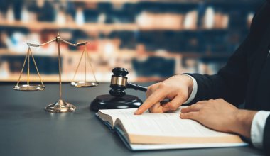 Avukatı ya da avukatı dava ya da dava açmaya hazırlanıyor, hukuk fakültesi konsepti için kütüphanedeki masasında hukuk kitabı okuyor ya da okuyor, hukuki sembollerle süslenmiş. Eşitlik