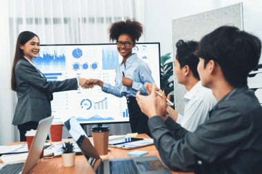 Çeşitli iş arkadaşları bunu şirket işyerinde el sıkışma ve takım çalışmasıyla kutluyor. Başarılı bir toplantıdan sonra el sıkışmayla ya da veri analizi üzerine iş sunumuyla birleşen mutlu iş adamları. Uyum