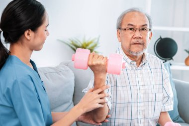Unyielding senior patient doing physical therapy with the help of his caregiver. Senior physical therapy, physiotherapy treatment, nursing home for the elderly