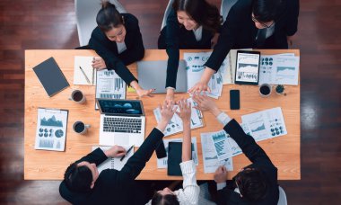 Top-view business team of financial data analysis meeting with business intelligence, report paper and dashboard on laptop for marketing strategy. Business people working together in office of harmony