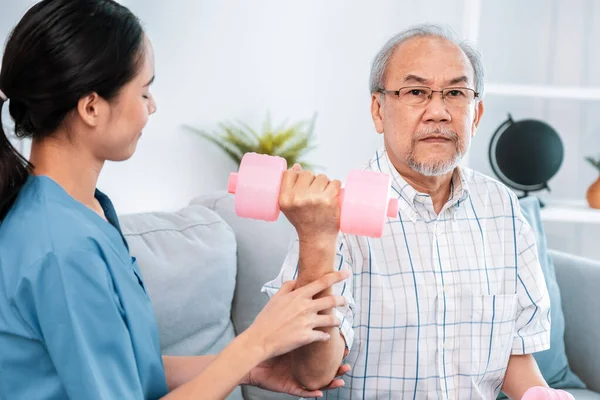 stock image Unyielding senior patient doing physical therapy with the help of his caregiver. Senior physical therapy, physiotherapy treatment, nursing home for the elderly