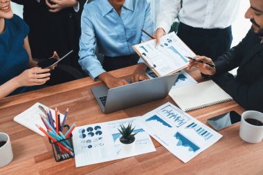 Çok ırklı analist ekibi toplantı masasındaki mali raporu analiz etmek için BI gösterge tablosunu kullanıyor. Çeşitli iş adamlarından oluşan bir grup, FIntech 'in veri analizini başarılı iş pazarlaması için kullanır. Uyum