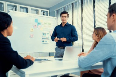 Competent office workers from various nationalities are debating, discussing and brainstorming in the meeting room. A group of employees is collaborating to achieve their business objectives.