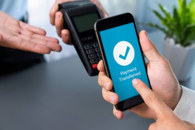 NFC QR kod cihazı ile el ele tutuşan akıllı telefon, hızlı dijital işlemler için temas kurulamayan ödeme kodlarını tarıyor. Modern yaşam tarzı ödeme teknolojisi için cep telefonundaki online bankacılık uygulaması. coşkulu