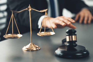 Hukuk bürosundaki masabaşında çalışan avukatın bulanık arka planına odaklan. Gavel, kanun koyucu ve avukatın adil ve eşit karar vermesi için çekiç. Eşitlik