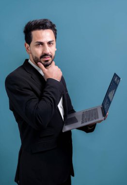 Yenilikçi teknoloji kavramına sahip başarılı bir iş adamı, ayakta duran, dizüstü bilgisayarı tutan ve telif alanı arka planında reklam ya da tanıtım için heyecanla gülümseyen. Coşkulu