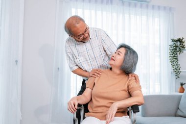 A contented senior couple and their in-home nurse. Elderly female in wheelchair with her young caregiver.