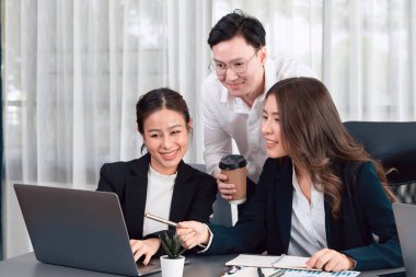 Harmony in office concept as business people analyzing dashboard paper together in workplace. Young colleagues give ideas at manager desk for discussion or strategy planning about project.