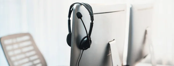 stock image Panorama view of empty call center operator workspace, focused on headset. Representing corporate customer service support and telesales communication technology. Prodigy