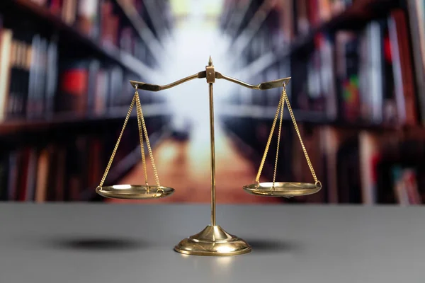 Shiny golden balanced scale in court library background as concept justice and fairness legal symbol. Scale balance for righteous and equality judgment by lawyer and attorney. equility