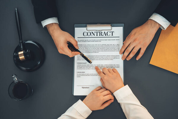 Top view lawyer colleagues or legal team working or drafting legal document at law firm office desk. Gavel hammer for righteous and equality judgment by lawmaker and attorney. Equilibrium