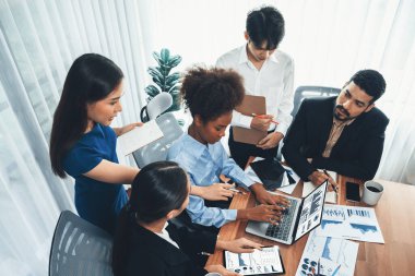 Çok ırklı analist ekibi toplantı masasındaki finansal verileri analiz etmek için BI Fintech yazılımı kullanıyor. Finansal konsol veri ekranında pazarlama göstergesi için analiz edilmiş grafikle birlikte. Uyum